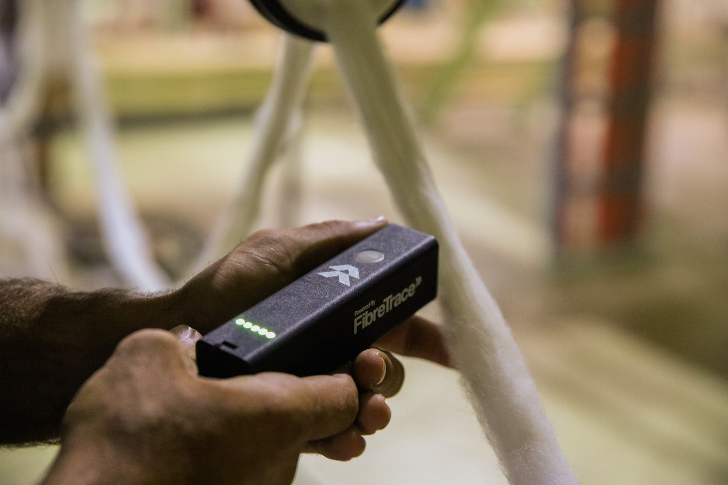 Proprietary handheld Fibretrace Bluetooth Scanner that identifies and quantifies pigments in fibre, yarn, fabric and finished goods that send encrypted data into secure blockchain and software that was specifically designed and engineered for the textile and apparel supply chain. © Fibretrace